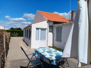 Maisonnette Individuelle Proche Centre Ville à La Faute-sur-Mer - FR-1-476-131 في لا فاوت سور مير: طاولة وكراسي أمام المبنى