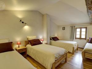une chambre avec deux lits et deux tables avec lampes dans l'établissement Gîte cosy avec jardin clos et animaux acceptés - FR-1-496-119, à Virigneux