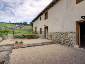 - une vue extérieure sur une maison avec un parasol dans l'établissement Gîte cosy avec jardin clos et animaux acceptés - FR-1-496-119, à Virigneux