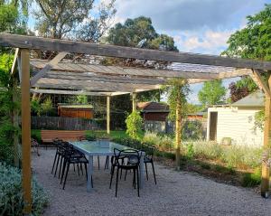 阿米代尔Boutique Cottage on Mann的木制凉亭下的桌子和椅子