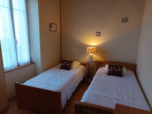 Zimmer mit 2 Betten und einer Lampe in der Unterkunft Maison Vendéenne avec Jardin - Animaux Admis - FR-1-540-168 in Notre-Dame-de-Monts