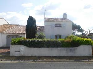 a white house with a hedge in front of it at Maison spacieuse 9 pers, secteur calme - FR-1-476-201 in La Faute-sur-Mer