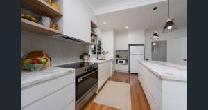 阿米代尔Boutique Cottage on Mann的配有白色橱柜和台面的厨房