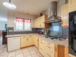 a kitchen with wooden cabinets and a stove top oven at Maison familiale climatisée à Biscarrosse - 6 pers, proche centre & pistes cyclables - FR-1-319-546 in Biscarrosse +19 photos