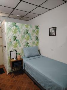 ein Schlafzimmer mit einem Bett und einer Wand mit einem Wandbild in der Unterkunft Surf City Rancho Los Hernandez El Tunco in Tamanique + 48 Fotos