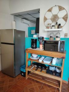 eine Küche mit einer Mikrowelle und einem Kühlschrank in der Unterkunft Surf City Rancho Los Hernandez El Tunco in Tamanique