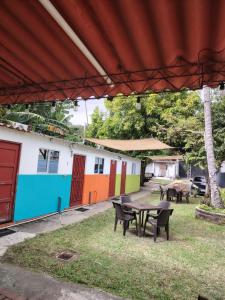 eine Terrasse mit Tischen und Stühlen vor einem Gebäude in der Unterkunft Surf City Rancho Los Hernandez El Tunco in Tamanique