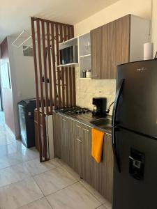 une cuisine avec un réfrigérateur noir et une cuisinière dans l'établissement Apartasuite en el Corazón del Eje Cafetero, à Pereira