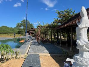 une statue d'une femme debout à côté d'un corps d'eau dans l'établissement Nguyen Shack Retreat Resort, à Phong Nha