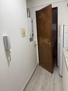 a door to a kitchen with a phone on the wall at Departamento en Chivilcoy in Chivilcoy +2 photos