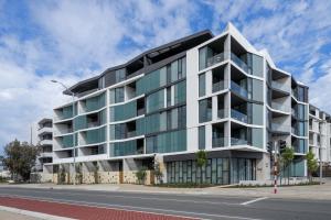 an apartment building on the corner of a street at Coastal Apartment with Rooftop Pool in North Fremantle