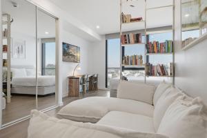 a living room with a white couch and a bedroom at Coastal Apartment with Rooftop Pool in North Fremantle