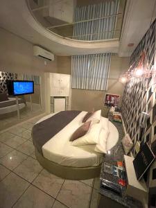 a bedroom with a large bed and a flat screen tv at Hotel Motel Paradiso - Tapera-RS in Tapera
