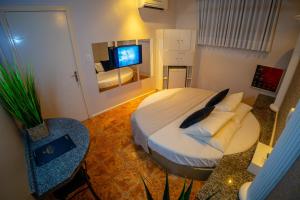 a bedroom with a bed and a television in it at Hotel Motel Paradiso - Tapera-RS in Tapera