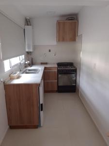 a kitchen with wooden cabinets and a refrigerator at Selene in Villa Rumipal +3 photos
