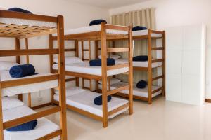 a room with several bunk beds in a room at Enseada Hostel in Arraial do Cabo