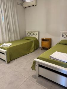 2 Betten in einem Zimmer mit Grün und Weiß in der Unterkunft mirante del cerro in Yerba Buena + 50 Fotos