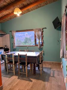 ein Esszimmer mit Tisch und Stühlen und einem Fenster in der Unterkunft Paraje la bendición in Tilcara