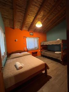 ein Schlafzimmer mit 2 Betten und einer orangefarbenen Wand in der Unterkunft Paraje la bendición in Tilcara