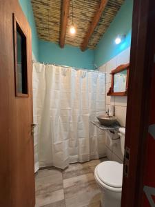 ein Badezimmer mit einem weißen Duschvorhang und einem WC in der Unterkunft Paraje la bendición in Tilcara