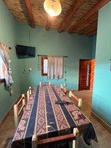 Ein großer Tisch mit Stühlen in einem Raum mit grünen Wänden in der Unterkunft Paraje la bendición in Tilcara