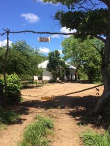 a sign in front of a house with a tree at Camp Zora Selous in Kwangwazi