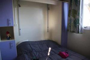 une chambre avec un lit avec une couette bleue et une fenêtre dans l'établissement Chalet 3 étoiles - Piscine - eeedeh, à Guérande