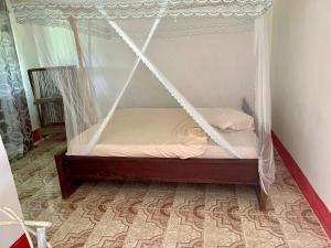 a bed with a canopy in a room at Camp Zora Selous in Kwangwazi