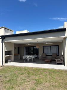 ein Haus mit einer Terrasse mit Tischen und Stühlen in der Unterkunft mirante del cerro in Yerba Buena