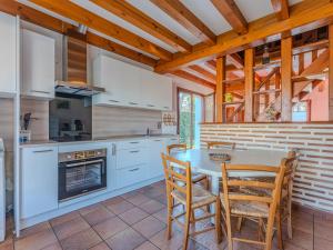 a kitchen with white cabinets and a table and chairs at Maison chaleureuse avec terrasse et jardin, proche plage et centre-ville - 6 pers, Biscarrosse - FR-1-521-34 in Biscarrosse-Plage