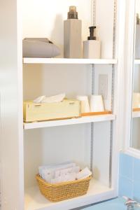 a shelf with books and other items on it at 羽地古民家 かめたろうやー in Nakaoshi