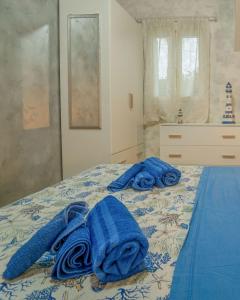 una camera da letto con asciugamani blu su un letto di La Perla di Marzamemi a Marzamemi