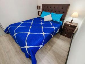 een slaapkamer met een blauw dekbed op een bed bij FLOREZ APT6 - Céntrico, acogedor con calefacción in La Paz