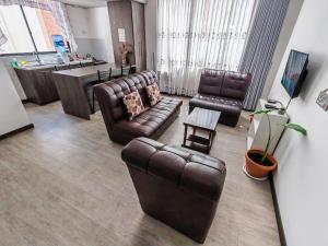 een woonkamer met 2 lederen stoelen en een tafel bij FLOREZ APT6 - Céntrico, acogedor con calefacción in La Paz