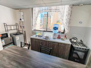 een keuken met een tafel, een fornuis en een raam bij FLOREZ APT6 - Céntrico, acogedor con calefacción in La Paz