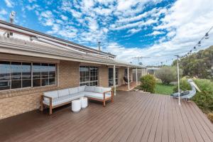 a patio with a white couch on a wooden deck at River Murray Views in Nildottie