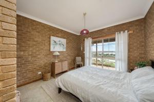 Un dormitorio con una cama y una pared de ladrillo. en River Murray Views, en Nildottie