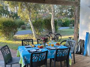 a table with a blue table cloth on a patio at Maison confortable 6 pers, terrasse, résidence avec piscine et parking proche mer - FR-1-239-1118 in Ondres
