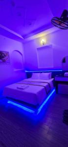 a bedroom with a bed with a blue light at Mina Motel 2 in Thuan An