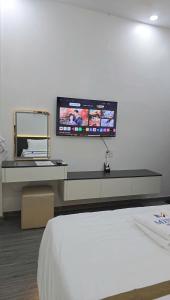 a room with a bed and a tv on the wall at Mina Motel 2 in Thuan An