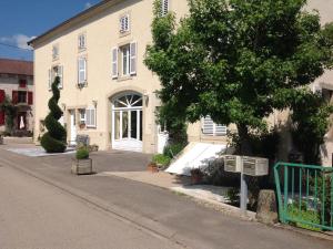 un bâtiment avec un arbre en face d'une rue dans l'établissement Gîte spacieux avec piscine et terrasse en village - FR-1-589-637, à Hennecourt