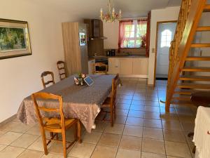 une cuisine et une salle à manger avec une table et des chaises dans l'établissement Gîte spacieux avec piscine et terrasse en village - FR-1-589-637, à Hennecourt
