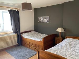 une chambre avec deux lits jumeaux et une fenêtre dans l'établissement Gîte spacieux avec piscine et terrasse en village - FR-1-589-637, à Hennecourt 9 autres photos