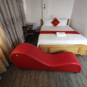 a red chair in a room with two beds at Song Đạt Hotel in Tân Ðiền