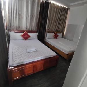two beds in a small room withskirts at Song Đạt Hotel in Tân Ðiền