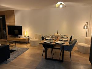 a living room with a table and chairs and a television at Nouveau ! Appartement de standing 3 chambres avec balcon et parking couvert - FR-1-836-42 in Les Carroz d'Araches