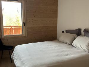 a white bed in a room with a window at Nouveau ! Appartement de standing 3 chambres avec balcon et parking couvert - FR-1-836-42 in Les Carroz d'Araches