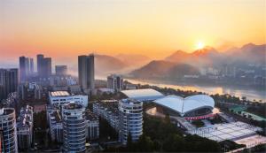 eine Stadt mit Gebäuden und einem Sonnenuntergang im Hintergrund in der Unterkunft Huangshan Tiandu International Hotel in Huangshan