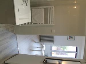 eine kleine Küche mit weißen Schränken und einer Treppe in der Unterkunft Appartement Rénové avec Cuisine Américaine et WIFI, Proche des Thermes Saint Roch - FR-1-541-32 in La Roche-Posay + 2 Fotos