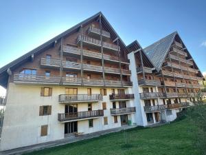un grand bâtiment avec des balcons sur le côté dans l'établissement Appartement Montagne 4 Pers, Balcon et Piscine - FR-1-814-162, à Super-Besse